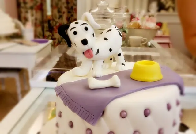 Il cucciolo dalmata sul cuscino con la ciotola gialla