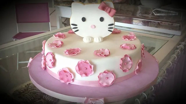 Torta bianca con muso di Hello Kitty e fiori rosa di zucchero