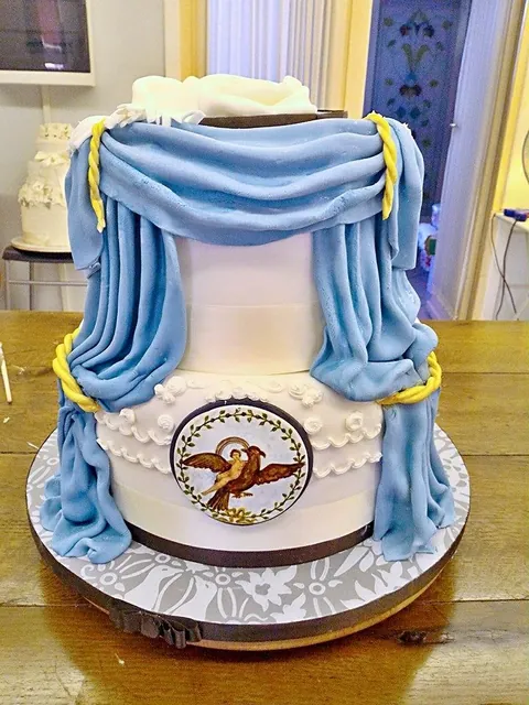 Torta teatrino vista da un altro lato, con le tende azzurre e il medaglione