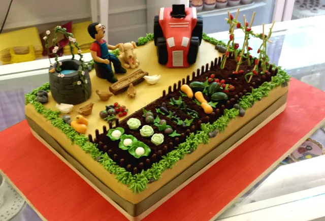 Torta rettangolare scenografica a forma di orto con verdure, contadino, cane, pozzo e trattore rosso