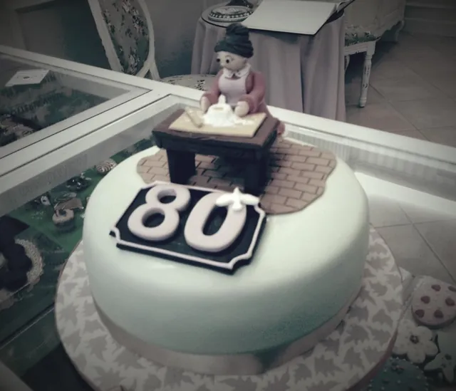 La torta degli ottant'anni con la nonnina che impasta sopra il 80