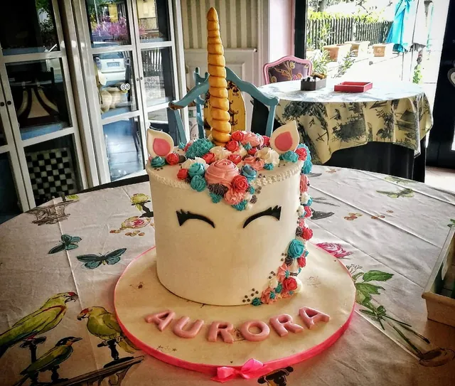 La torta unicorno intera con base rosa e fiori