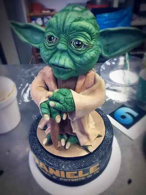 Primo piano del volto e delle mani di Yoda in pasta di zucchero