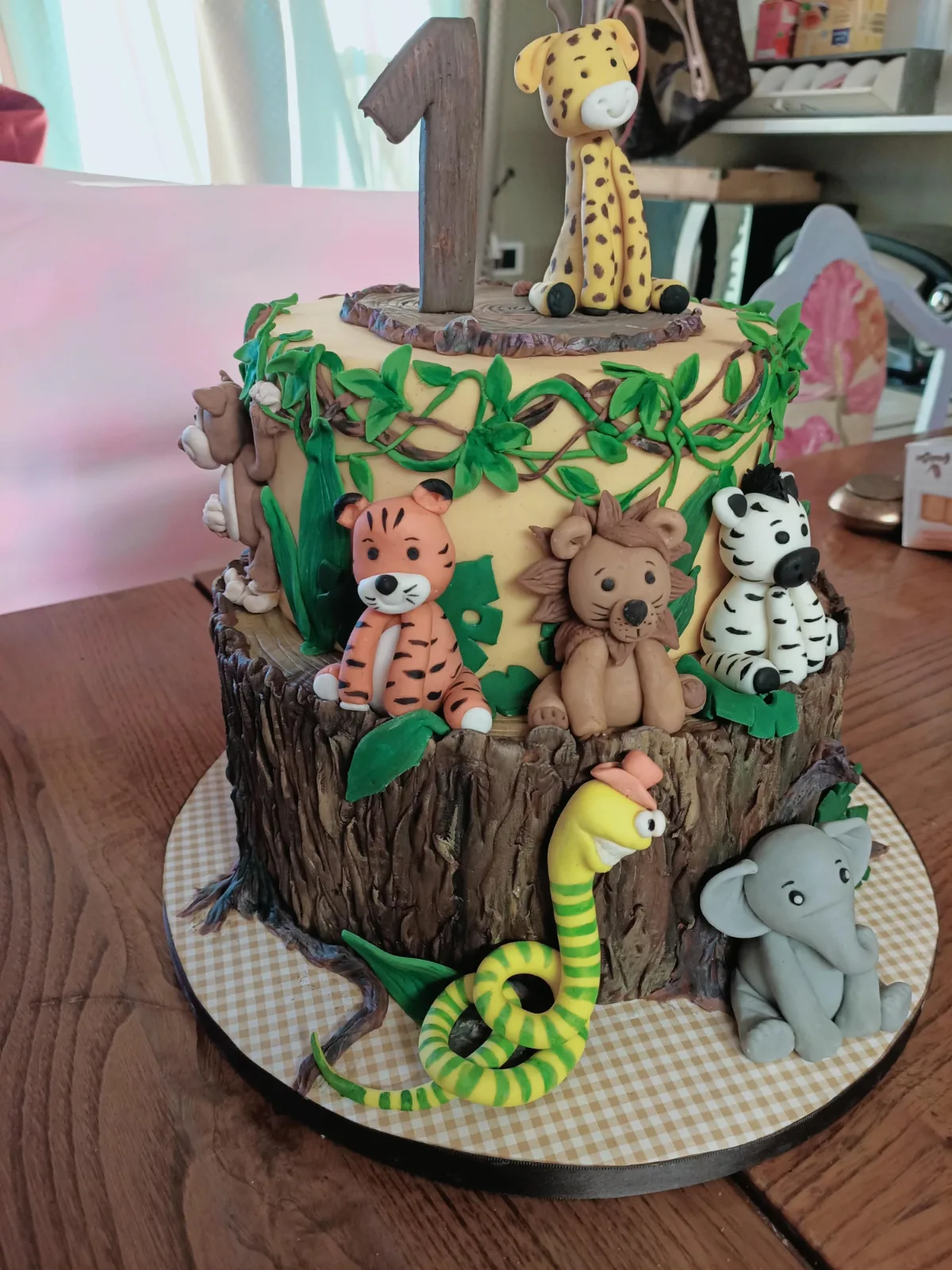 Torta a 2 piani con animali e i piani riprendono la forma di un tronco di albero